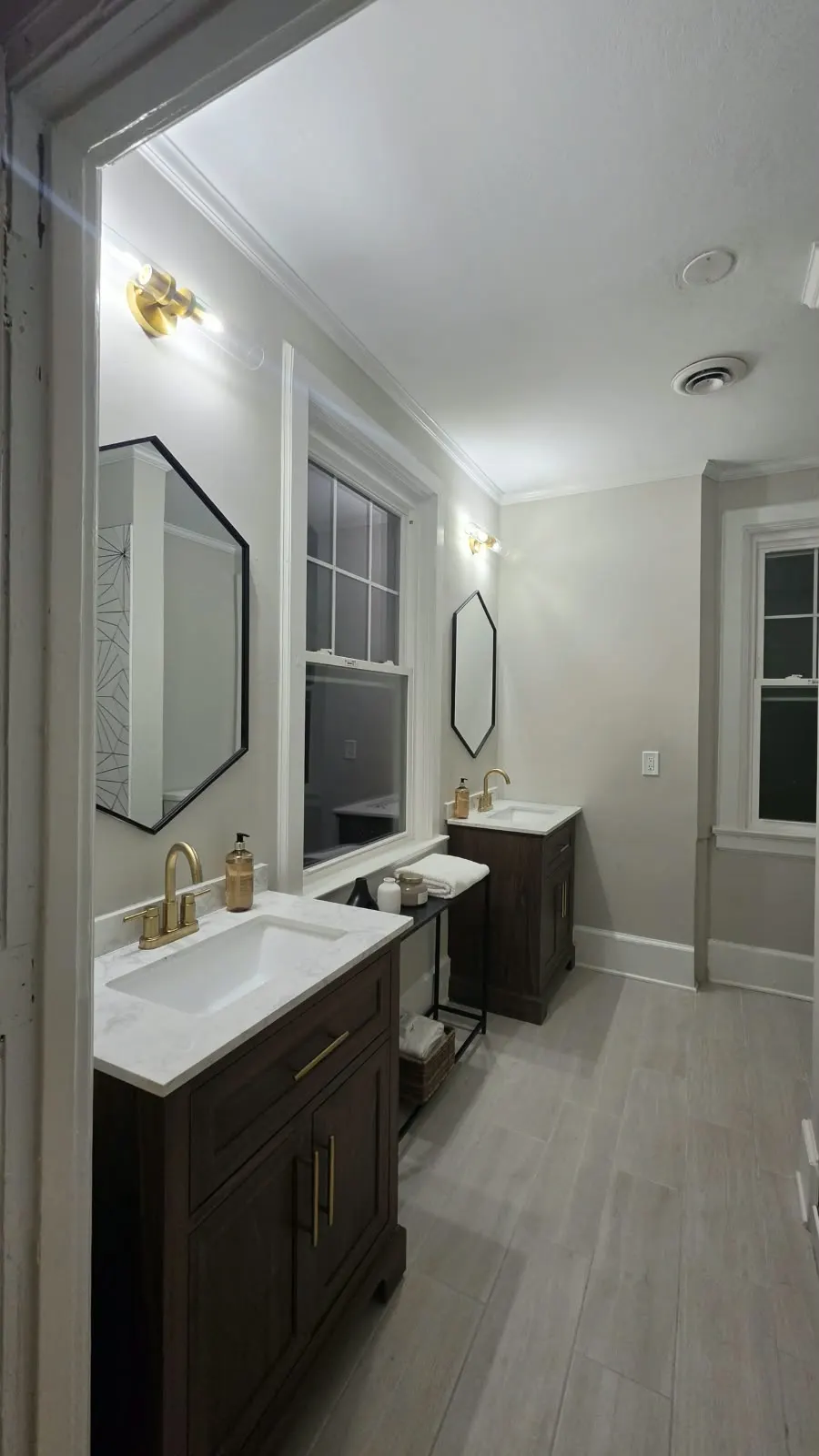 Remodeled bathroom with a dark vanity and gray plank floor in Hampton, VA