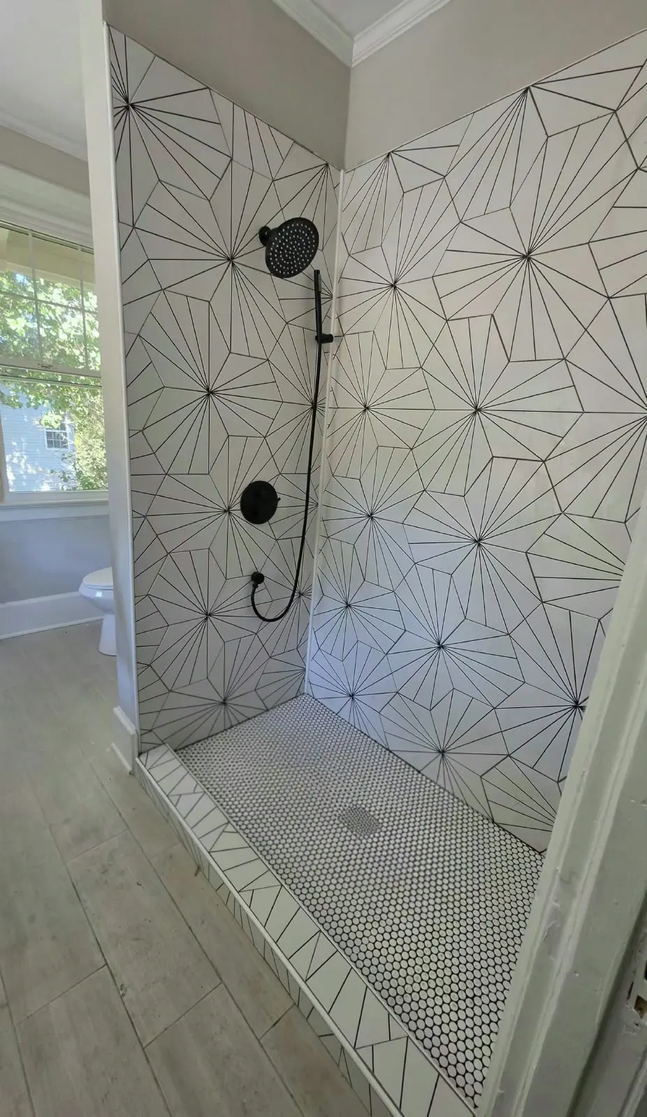 Walk-in shower with geometric hex tile and black fixtures in Hampton, VA
