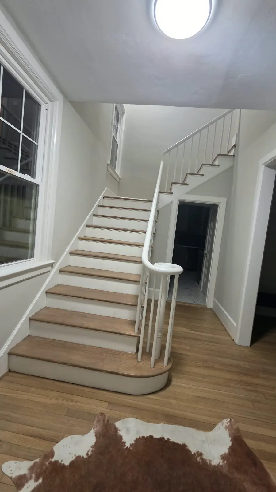 Staircase with natural-wood treads and a white railing in Hampton, VA